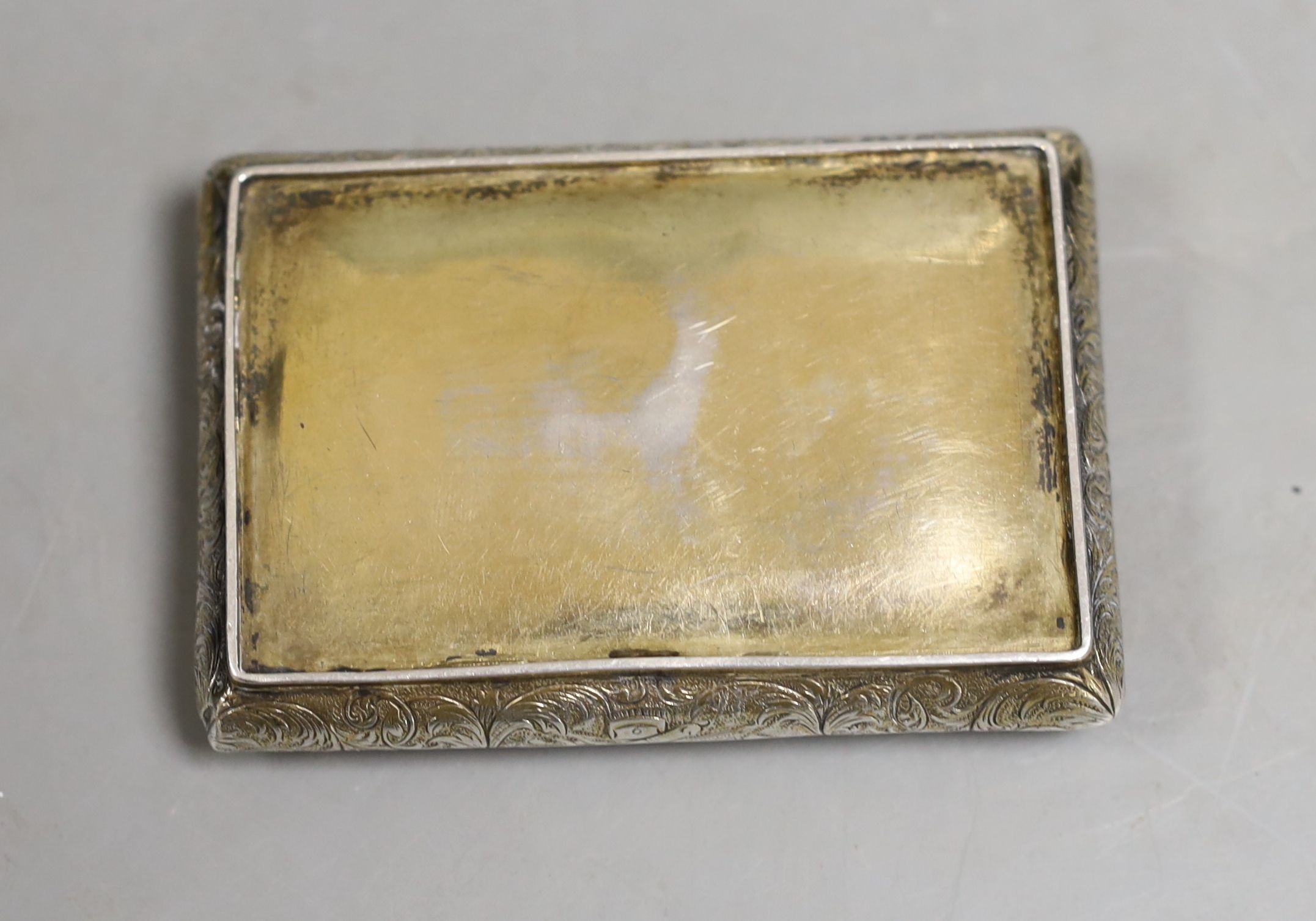 A 19th century continental gilt white metal rectangular bombe shaped snuff box, embossed with foliate scrolls and central stag hunting scene, unmarked, 81mm.